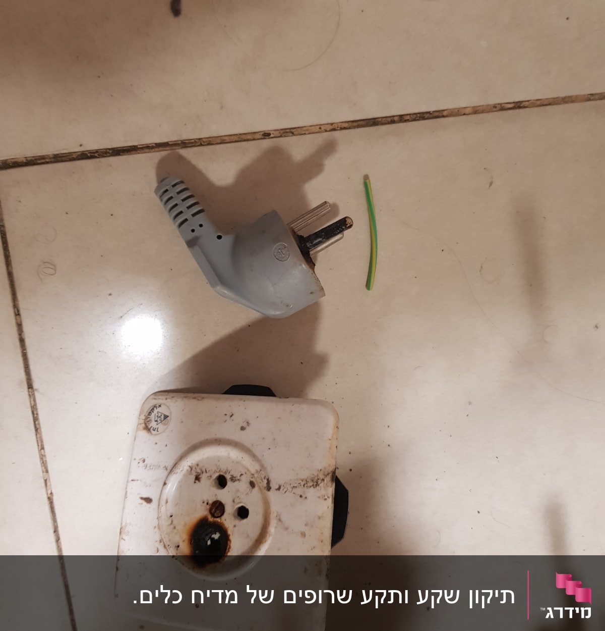 תקע חשמלי שבור ושקע עם סימני שריפה